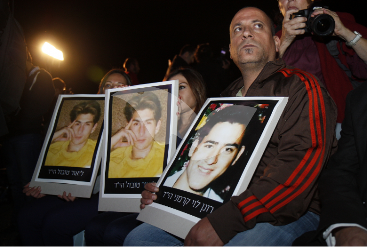 Terror victim families with photos of their loved ones at a demonstration against releasing prisoners in 2013