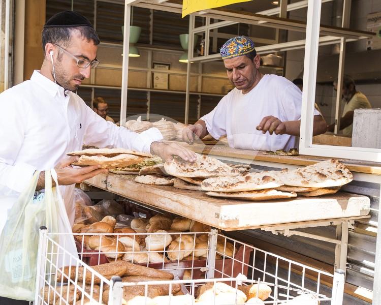 Religious Man Buys Pita Bread for Shabbat at Mahane Yehuda Market