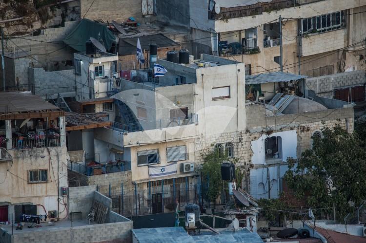 An Israeli flag hangs on a building in east Jerusalem neighborhood of Silwan