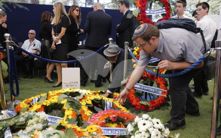 Bowing heads at the grave of the late Shimon Peres following his funeral.
