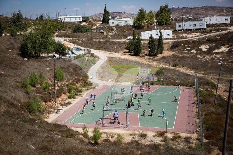 Children of Amona Settlement Play Football at the Local Sports Ground