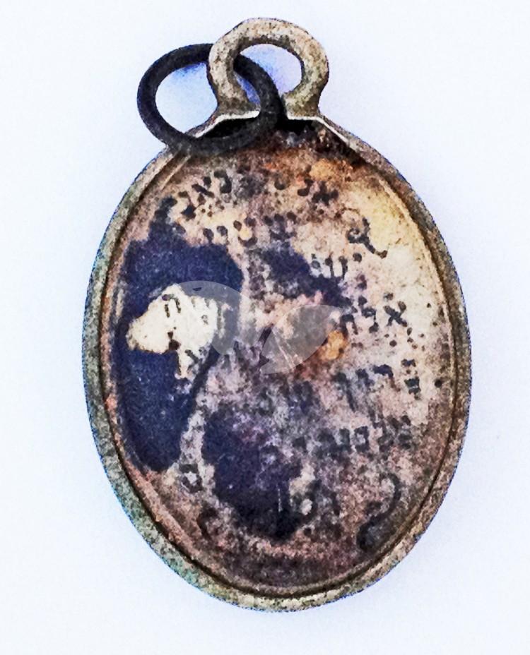 The reverse side of the metal locket covered with glass and engraved with the fundamental  Jewish prayer “Shema”