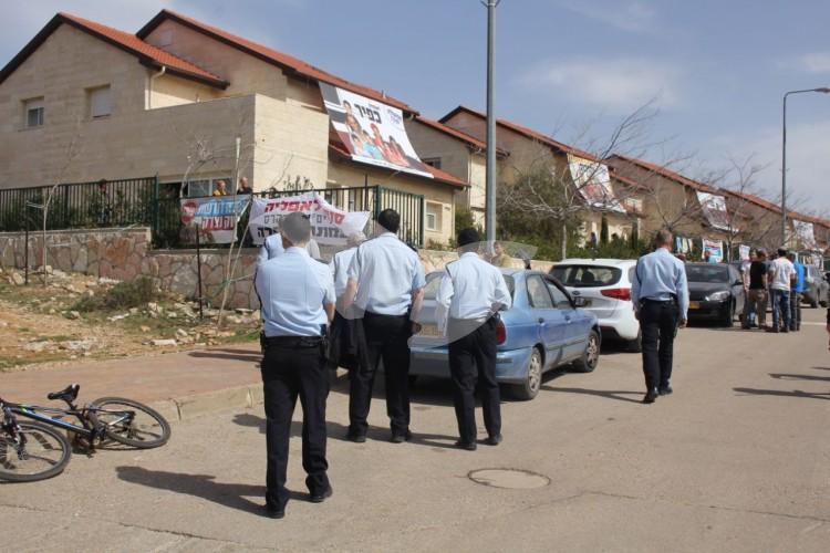 Police officers patrol the street of the nine houses in Ofra