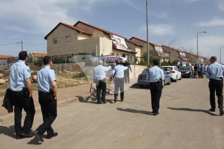 Police officers patrol the street of the nine houses in Ofra