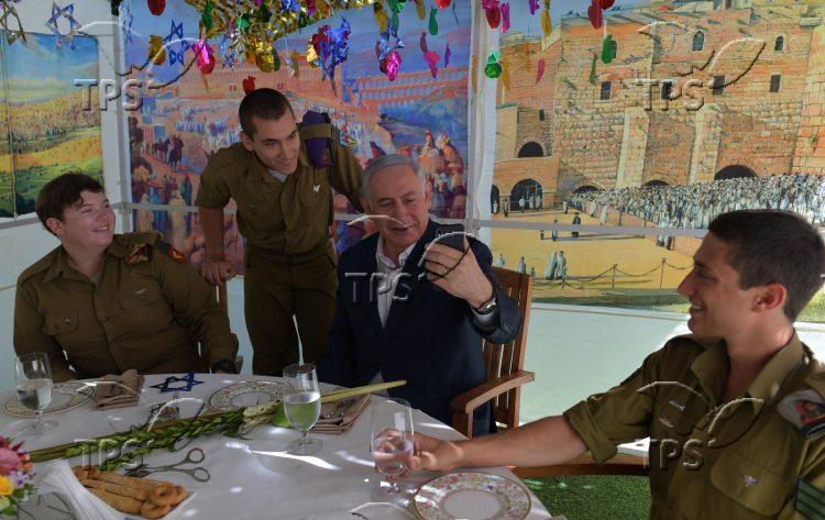 PM Netanyahu hosts lone soldiers in his sukkah