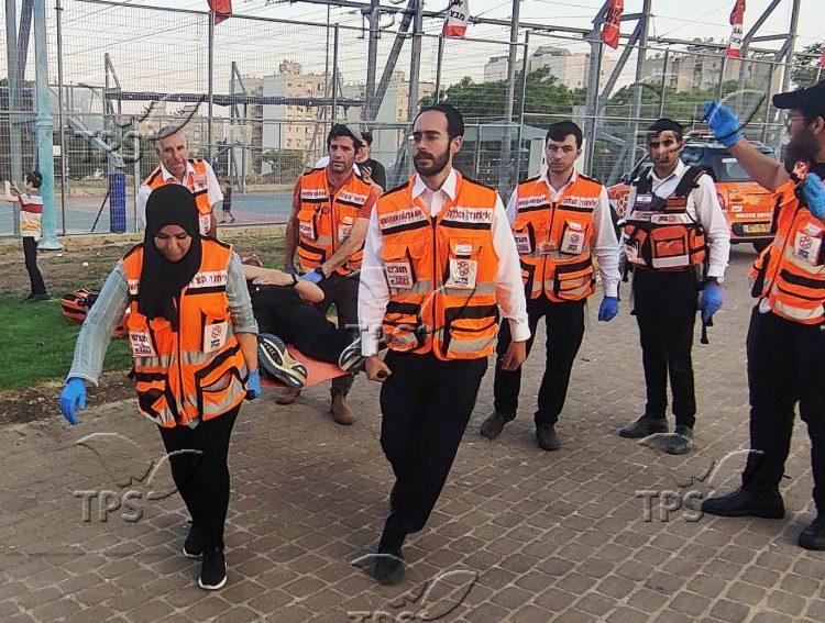 Muslim, Jewish, and Christian responders carry a patient with simulated injuries to a waiting ambulance