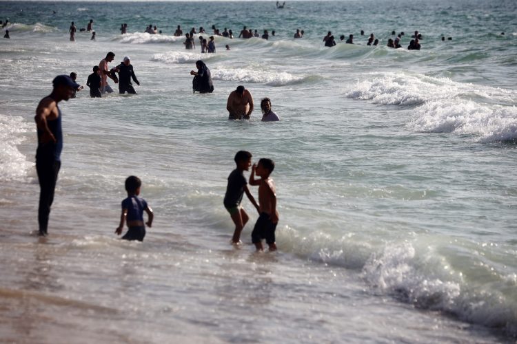Palestinians enjoy the sea during the Iron Swords War